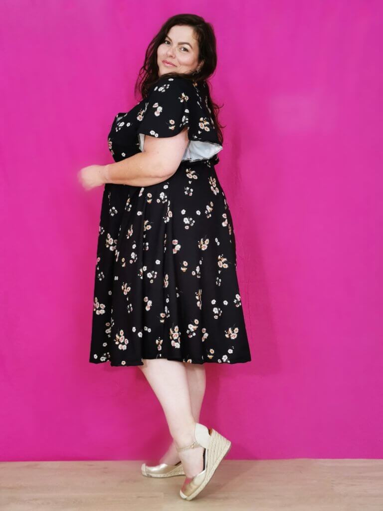 photo portrait d'une femme ronde, brune avec une robe noir avec des motifs de couleurs