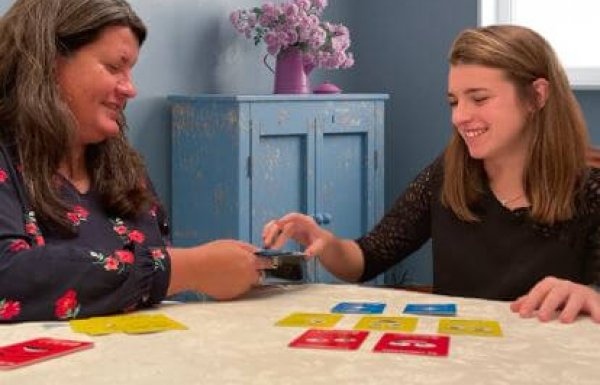 photo d'une femme et d'une jeune fille jouant aux cartes vue de face