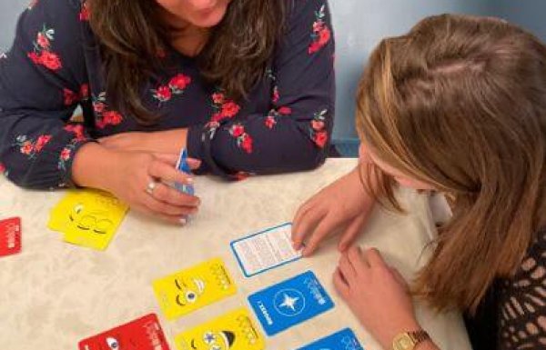 photo d'une femme et d'une fillette jouant à un jeu de carte vue du dessus